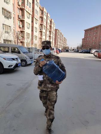 第十四师水利管理处预备党员陈志军为自己所服务的居家隔离人员进行送水服务。孙柏平摄。